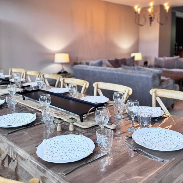 Salon chaleureux du gîte Grand Tétras avec canapés et grande table en bois