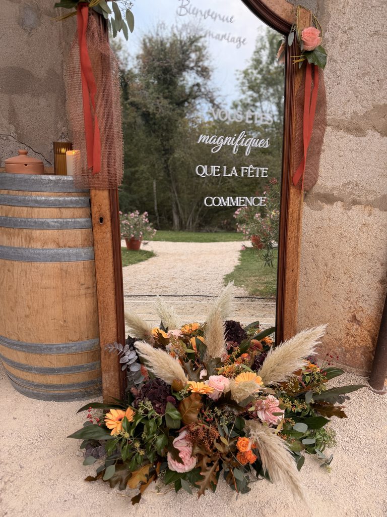 Miroir d'accueil et tonneau en bois décorés pour un mariage au Domaine Pré-Jeantet